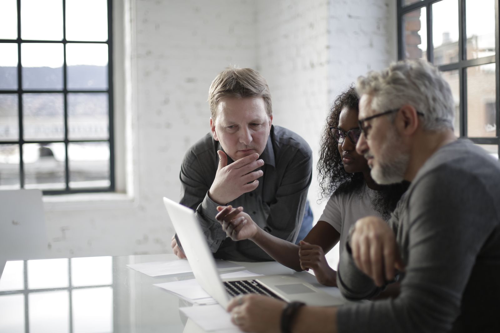 Team working through a campaign plan around a laptop